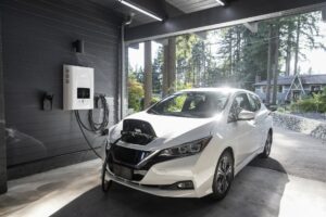A white electric vehicle charging in a garage at a residential home